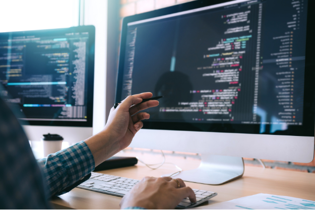 Bildschirm mit HTML-Code für Embedded Software, ein Software Developer erklärt seine Arbeit am Screen